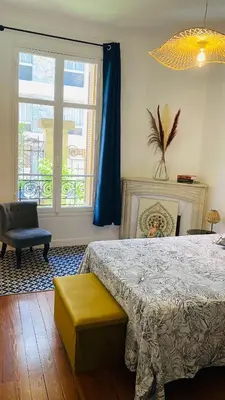 a bedroom with a bed and a chair and a window at Appartement - Cannes proche Croisette avec jardin in Cannes