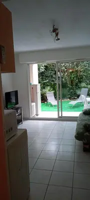 a living room with an open door to a yard at 2P en RDJ dans résidence avec piscine et tennis, proche Cannes et commodités in Le Cannet