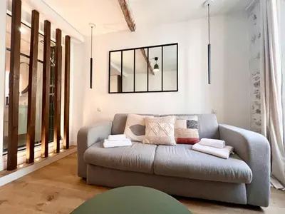 a living room with a couch and a mirror at B066 Studio design à 5 mn de la plage in Cannes