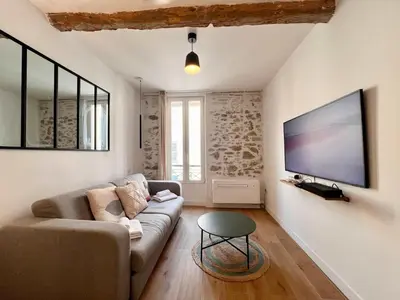 a living room with a couch and a flat screen tv at B066 Studio design à 5 mn de la plage in Cannes