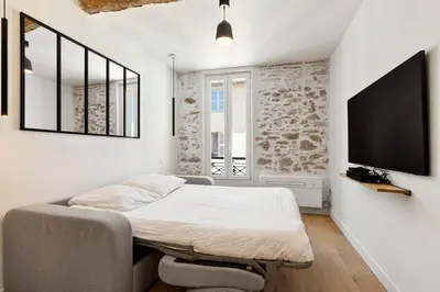 a room with a bed and a flat screen tv at B066 Studio design à 5 mn de la plage in Cannes