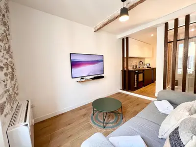 a living room with a couch and a tv on a wall at B066 Studio design à 5 mn de la plage in Cannes