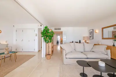 a living room with a white couch and a table at Georges III - Apartment with panoramic view of Cannes in Cannes