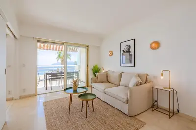 a living room with a couch and a table at Georges III - Apartment with panoramic view of Cannes in Cannes