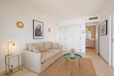 a white living room with a couch and a table at Georges III - Apartment with panoramic view of Cannes in Cannes