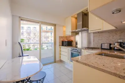 a kitchen with a counter top and a table at Georges III - Apartment with panoramic view of Cannes in Cannes