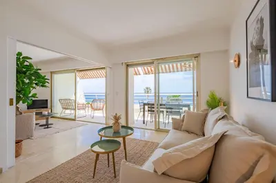 a living room with a couch and a table at Georges III - Apartment with panoramic view of Cannes in Cannes