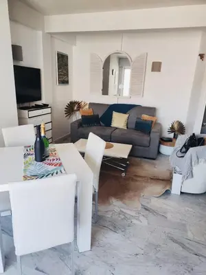 a living room with a couch and a table and chairs at Appartement Cannes Centre Proche de la Croisette! in Cannes