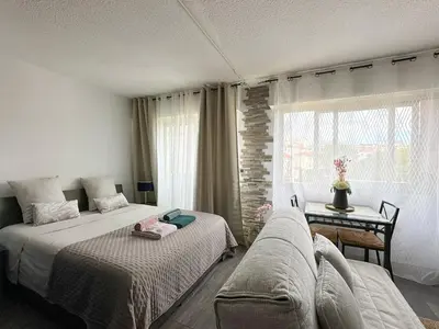 a bedroom with two beds and a couch at Cet été à Cannes, Studio cosy à 8' de la Croisette in Cannes