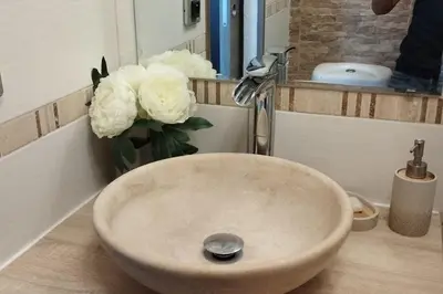 a sink in a bathroom with a vase of white flowers at Cet été à Cannes, Studio cosy à 8' de la Croisette in Cannes