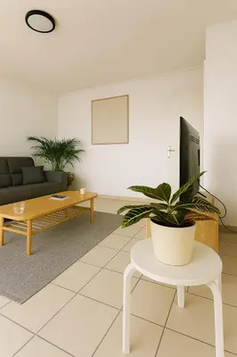 a living room with a couch and a table and a plant at Charmant appartement avec terrasse in Le Cannet