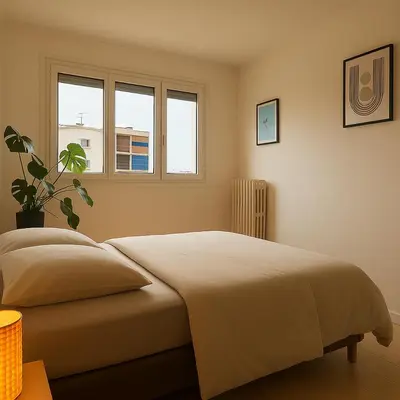 a bedroom with a bed and two windows at Charmant appartement avec terrasse in Le Cannet
