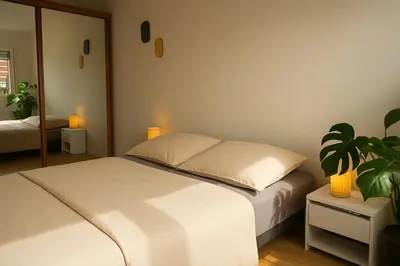 a bedroom with a white bed and a plant at Charmant appartement avec terrasse in Le Cannet