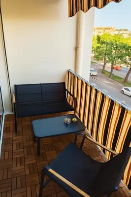 a bench and a table on a balcony at Charmant appartement avec terrasse in Le Cannet