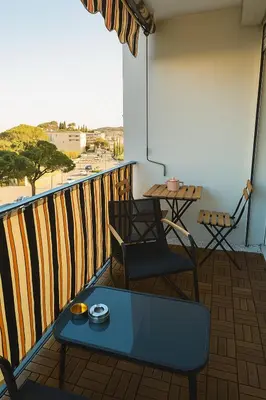 a balcony with a table and chairs and a view at Charmant appartement avec terrasse in Le Cannet
