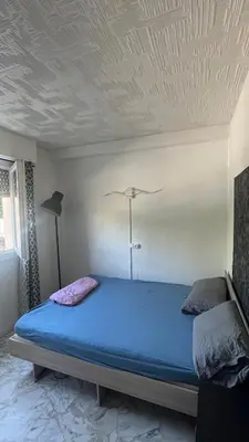 a bedroom with a blue bed with a ceiling at Appartement studio Cannes in Cannes