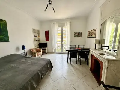 a bedroom with a bed and a table and chairs at 242 Cannes La Croisette - PALAIS MIRAMAR - Studio au calme coté jardin in Cannes