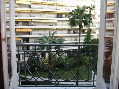 an open window with a view of a building at 242 Cannes La Croisette - PALAIS MIRAMAR - Studio au calme coté jardin in Cannes