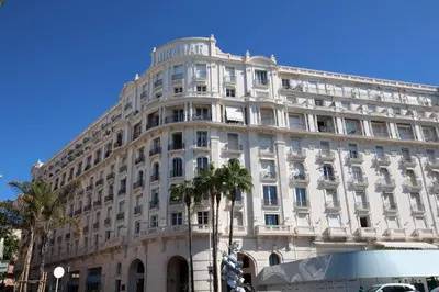a large white building with palm trees in front of it at 242 Cannes La Croisette - PALAIS MIRAMAR - Studio au calme coté jardin in Cannes
