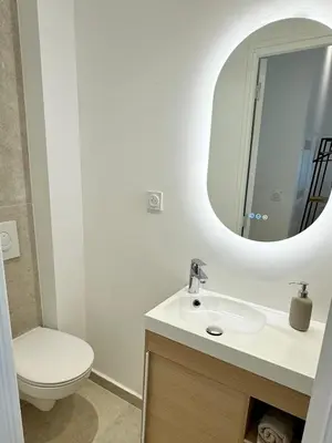 a bathroom with a sink and a toilet and a mirror at Charming appartement 3BR - 3BA - 3WC in Cannes
