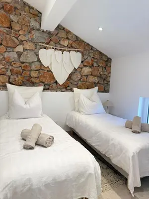 two beds in a room with a brick wall at Charming appartement 3BR - 3BA - 3WC in Cannes