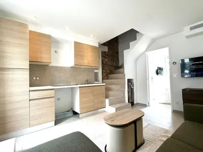 a living room with a staircase and a table and a stool at Charming appartement 3BR - 3BA - 3WC in Cannes