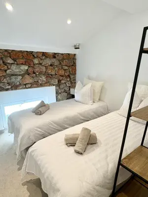 two beds in a room with a stone wall at Charming appartement 3BR - 3BA - 3WC in Cannes