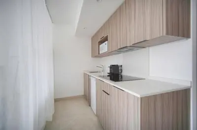 a kitchen with wooden cabinets and a counter top at Sublime Studio TERRASSE, Edith Cavell- proche CROISETTE A0B196 in Cannes