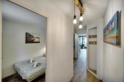 a hallway with a mirror and a bed in a room at Eva - Piscine - Terrasse - VCA in Cannes