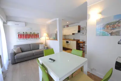 a living room with a white table and green chairs at superbe appartement tout confort beg4012 in Cannes