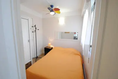 a small bedroom with a bed and a ceiling fan at superbe appartement tout confort beg4012 in Cannes