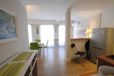 a kitchen with a refrigerator and a table and chairs at superbe appartement tout confort beg4012 in Cannes