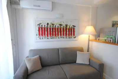 a living room with a couch and a painting on the wall at superbe appartement tout confort beg4012 in Cannes