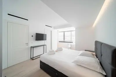 a white bedroom with a bed and a flat screen tv at Charming oasis with terrace 4 BD- 8P - Cannes in Cannes