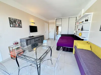 a living room with a table and a couch at Cannes proche Croisette - 2 pièces au calme avec terrasse in Cannes