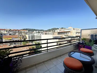 a balcony with chairs and a view of a city at Cannes proche Croisette - 2 pièces au calme avec terrasse in Cannes