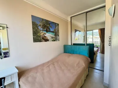 a bedroom with a bed and a view of a beach at Cannes proche Croisette - 2 pièces au calme avec terrasse in Cannes