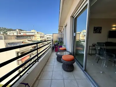 a balcony with a table and chairs on a building at Cannes proche Croisette - 2 pièces au calme avec terrasse in Cannes