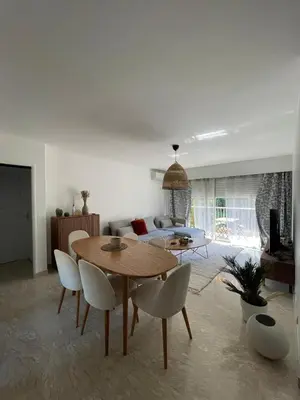 a living room with a table and chairs and a couch at Riad by L'Oliveraie in Cannes