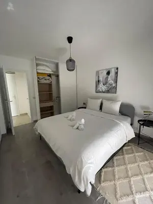 a large white bed with two stuffed animals on it at Riad by L'Oliveraie in Cannes