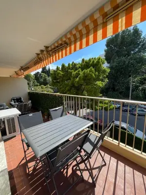 a picnic table and chairs on a deck with a balcony at Riad by L'Oliveraie in Cannes