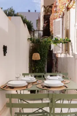 a green table with plates and glasses on it at La Vela Azzurra - terrasse, clim, 15 mn à pied du Palais et plages in Cannes