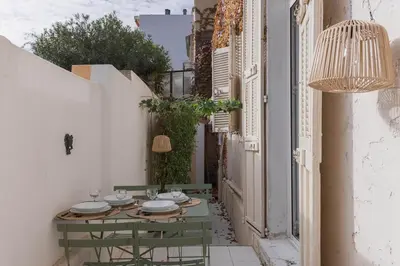 an alley with a table and chairs in a building at La Vela Azzurra - terrasse, clim, 15 mn à pied du Palais et plages in Cannes