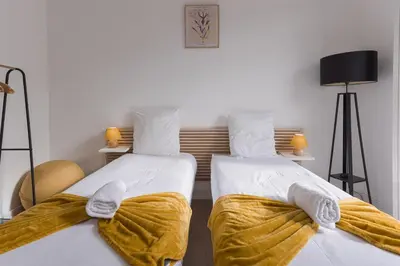 two beds in a room with yellow blankets at La Vela Azzurra - terrasse, clim, 15 mn à pied du Palais et plages in Cannes