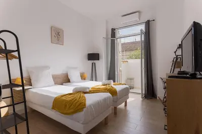a bedroom with two beds and a large window at La Vela Azzurra - terrasse, clim, 15 mn à pied du Palais et plages in Cannes