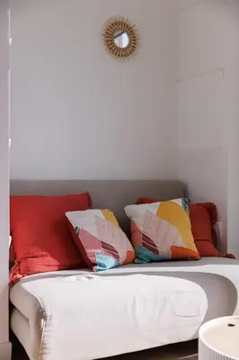 a couch with colorful pillows on top of it at La Vela Azzurra - terrasse, clim, 15 mn à pied du Palais et plages in Cannes