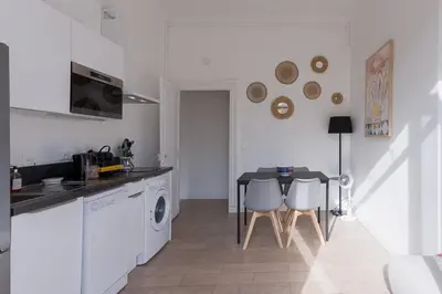 a kitchen with a washing machine and a table at La Vela Azzurra - terrasse, clim, 15 mn à pied du Palais et plages in Cannes