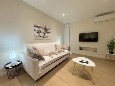 a living room with a white couch and a tv at Le studio Palm Beach, Clim ,Parking, Neuf in Cannes