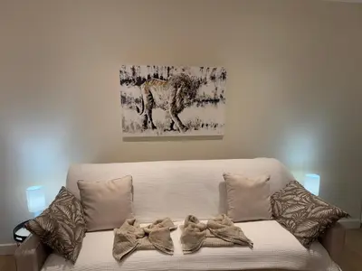 a couch with pillows and a painting on the wall at Le studio Palm Beach, Clim ,Parking, Neuf in Cannes