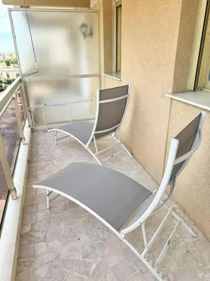 a kitchen with two chairs and a refrigerator at Le studio Palm Beach, Clim ,Parking, Neuf in Cannes